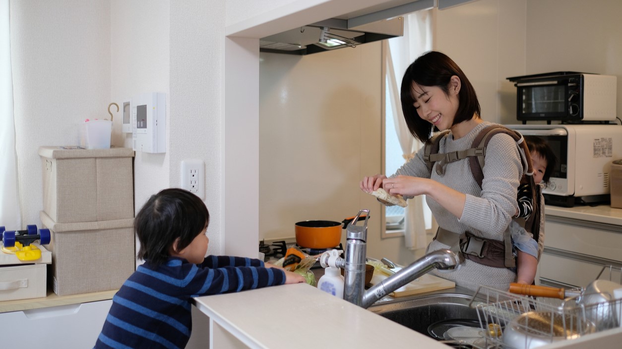 子どもを見ながら家事をする女性